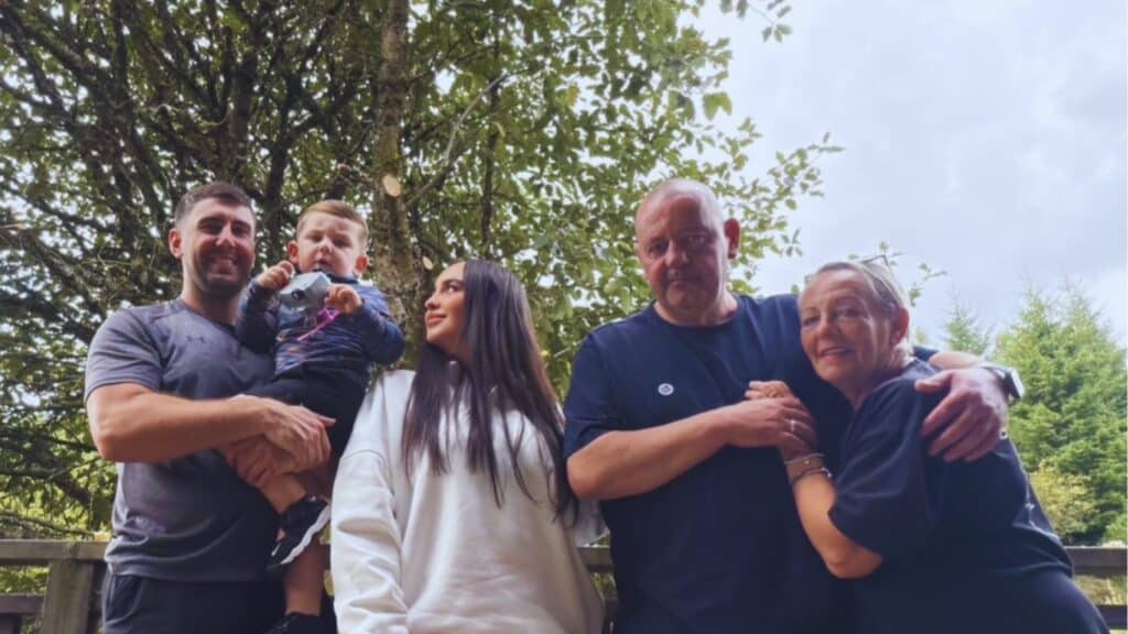 Becky and her family standing together beneath a tree during their stay at Calvert Kielder