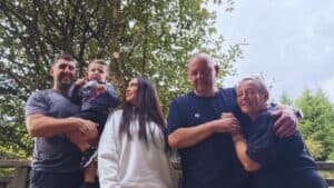 Becky and her family standing together beneath a tree during their stay at Calvert Kielder