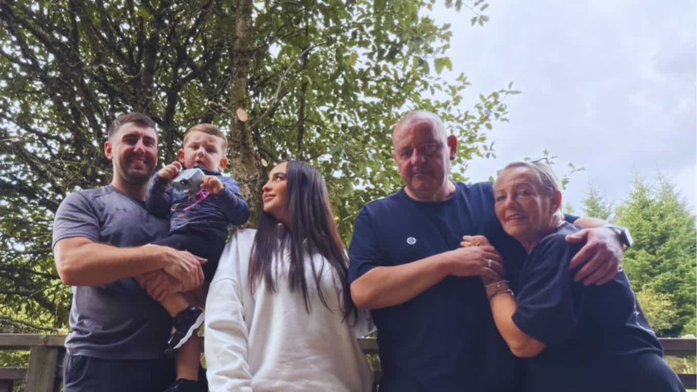 Becky and her family standing together beneath a tree during their stay at Calvert Kielder