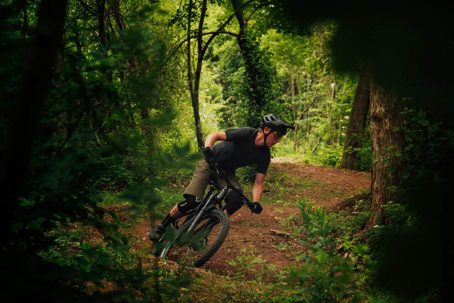 Mountain biker cornering on a woodland trail